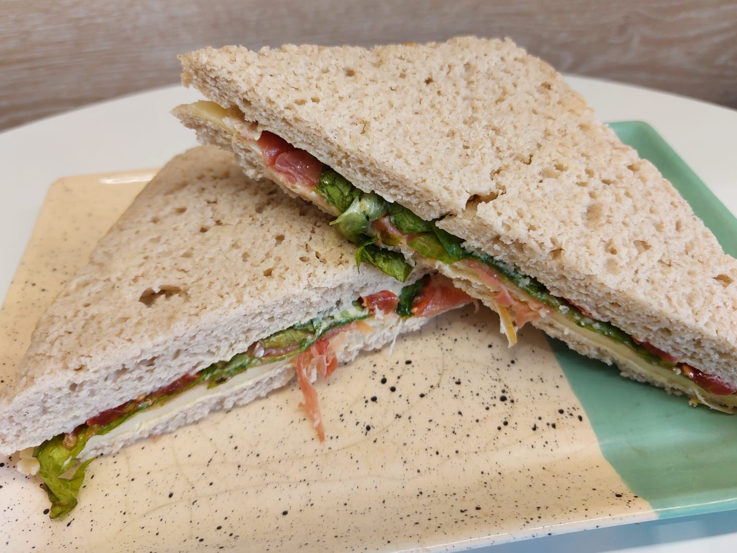 Sandwich de Miga negro jamón crudo queso y rucula