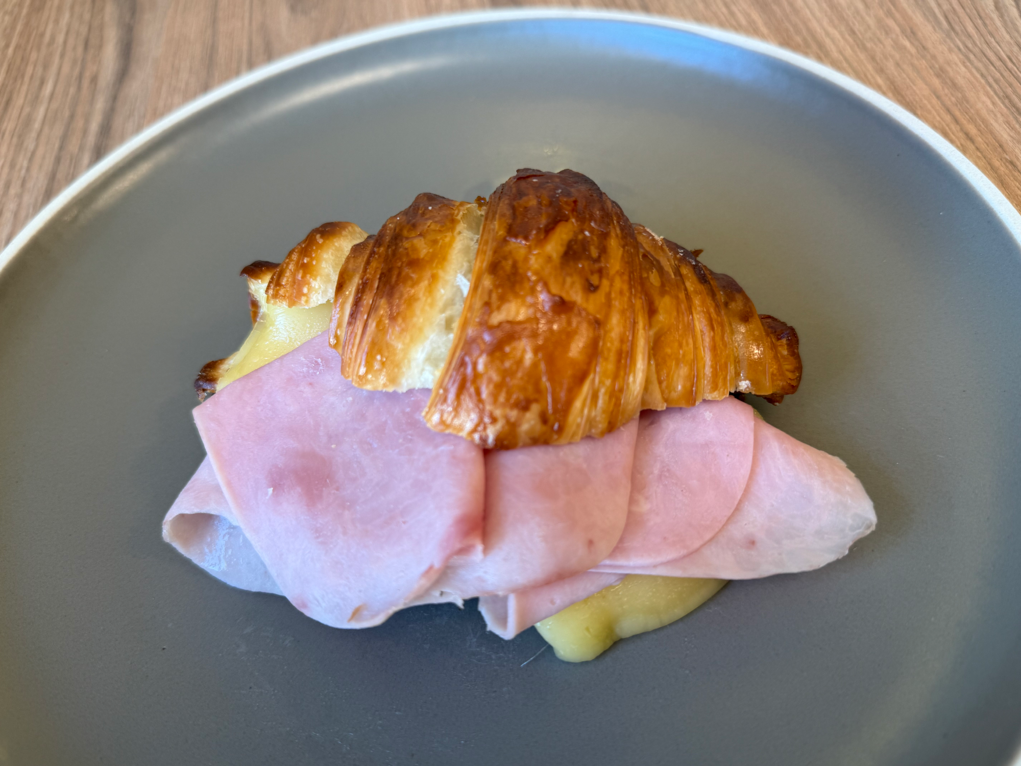Croissant tibio relleno de jamón y queso
