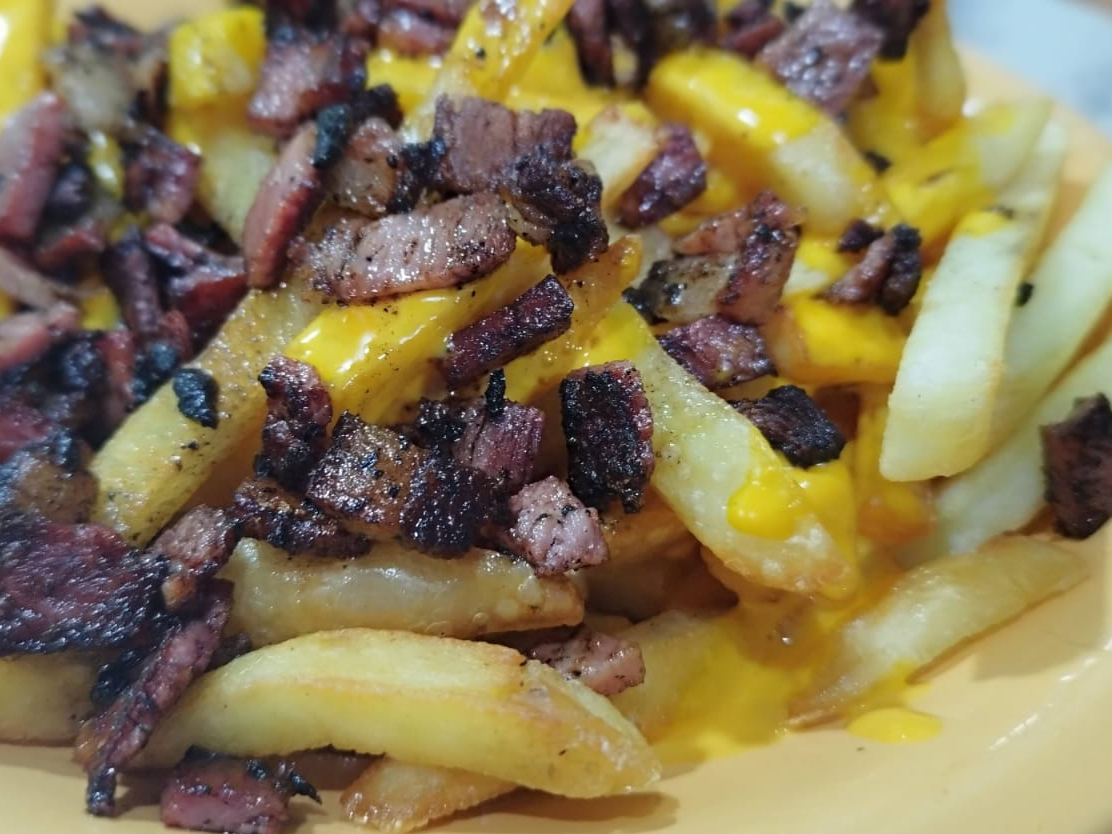 Porción de papas con cheddar y panceta