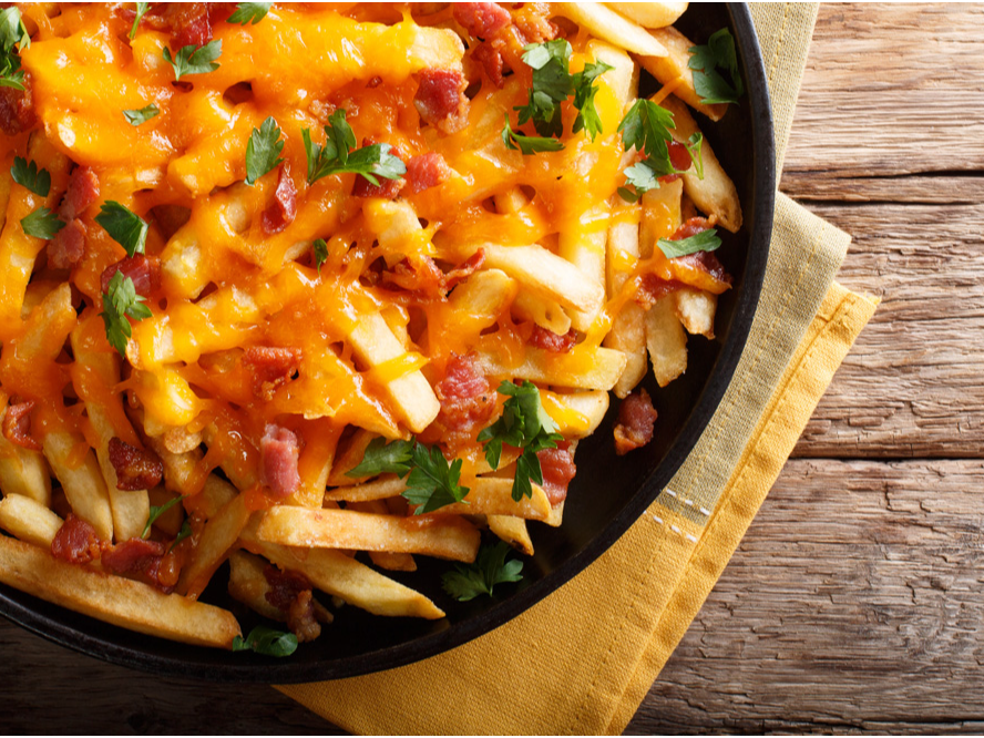 Papas fritas con cheddar, panceta y verdeo