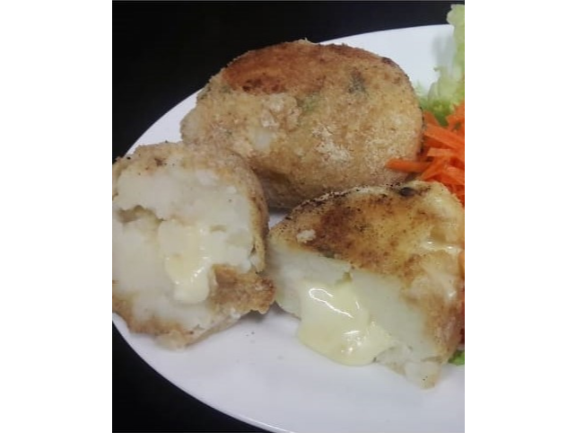 Menu Vegetariano. Bombas de papa rellenas de queso sobre colchón de rucula, tomates asados y aceitunas