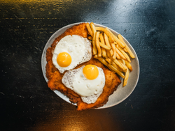 Milanesa o suprema a caballo con guarnición.