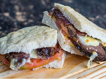 Ciabatta de Bondiola a las Hierbas con tomate y cebolla caramelizada de Rincón del bajo
