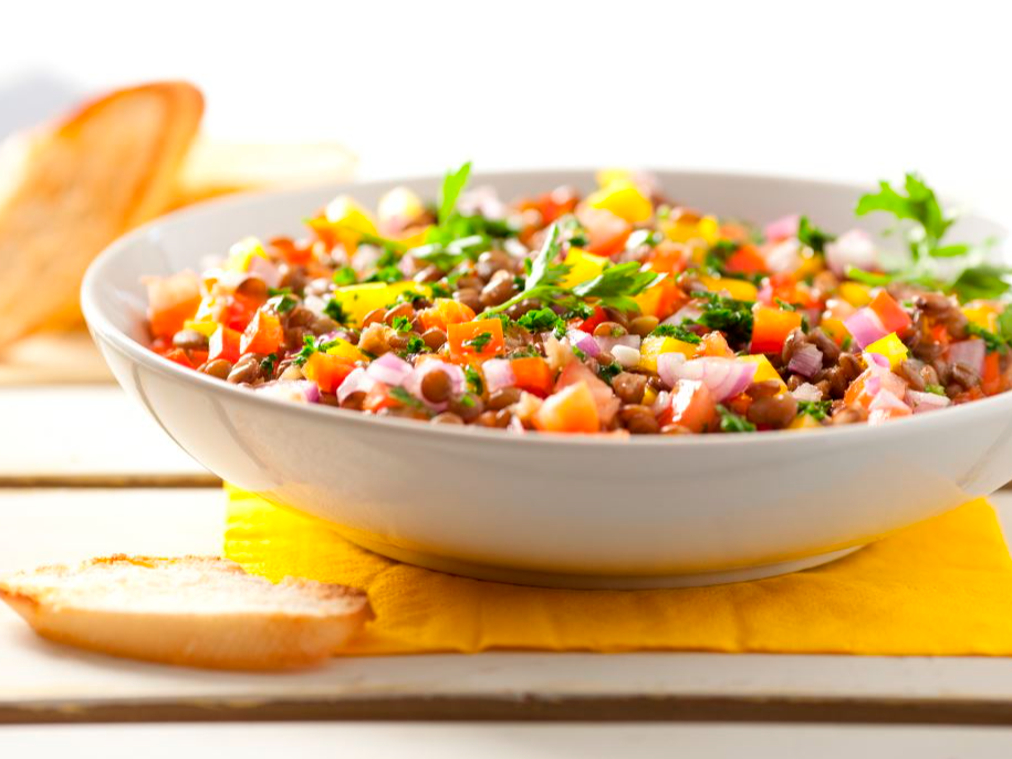 Ensalada mediterránea de garbanzos, tomate, pepino, cebolla morada, aceitunas y queso en cubos.