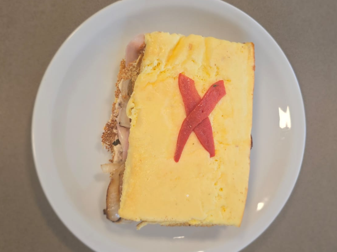 9. Sándwich de pan nube con atún, cebolla, pimiento, tomates, queso y huevo duro rallado.