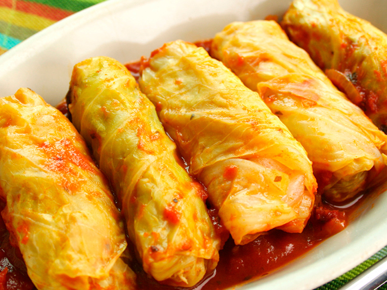 21. Niños envueltos con relleno de verduras asadas y queso sobre salsa roja.
