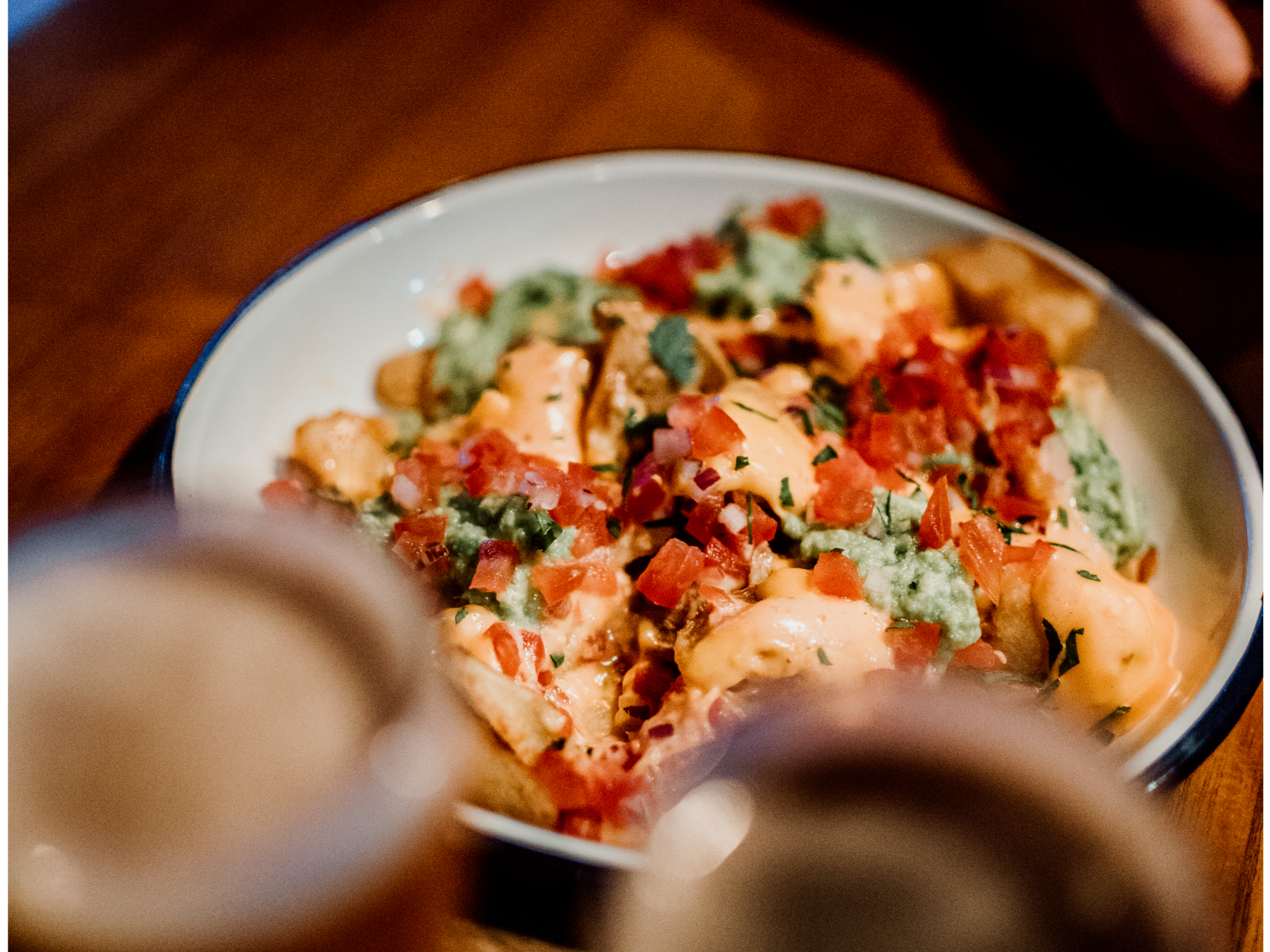 Papas con cheddar, guacamole y mayo picante de Al Bosque Cervecería de Montaña