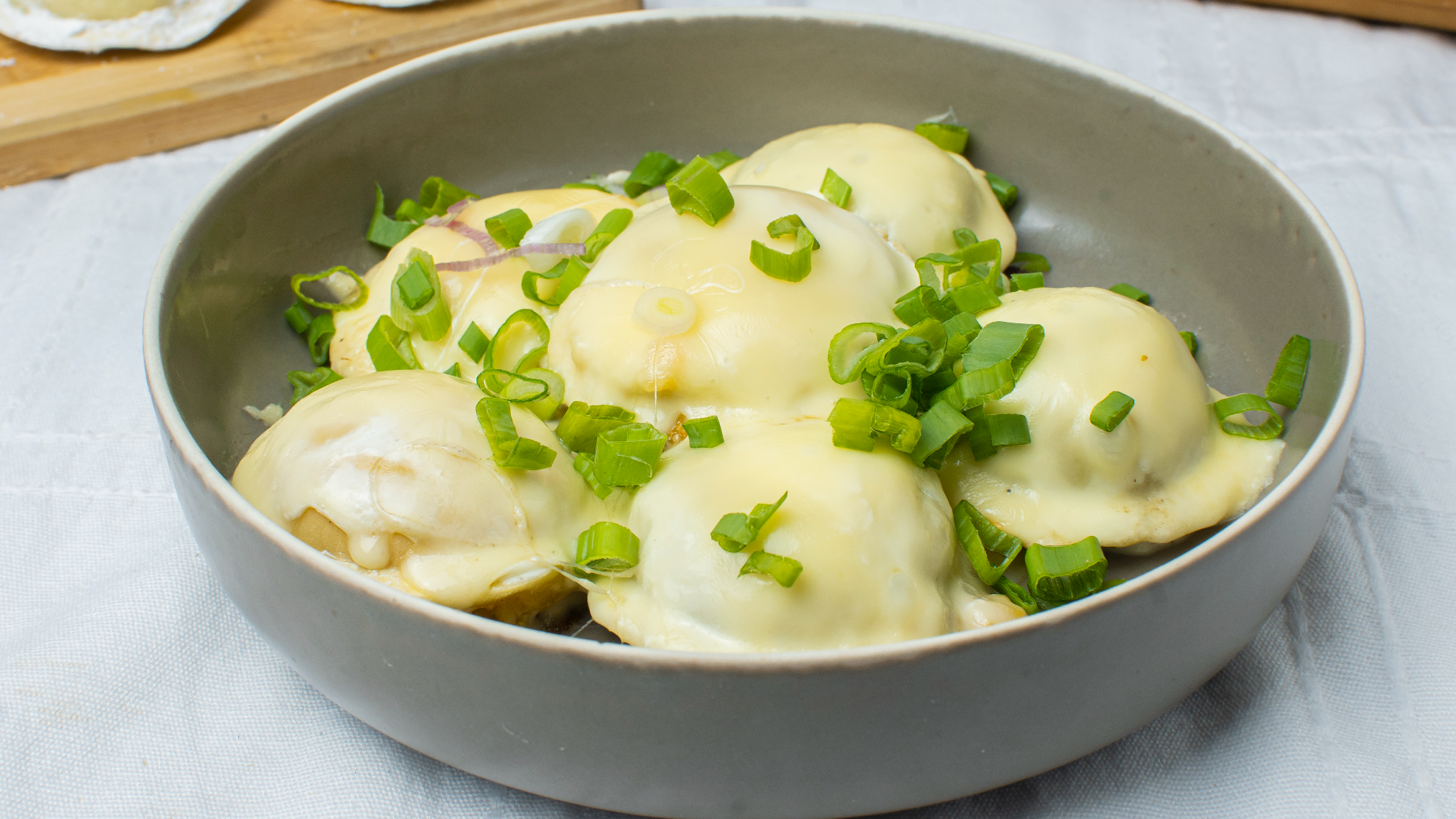 sorrentinos horneados y  gratinados con crema , queso , cebolla de verdeo