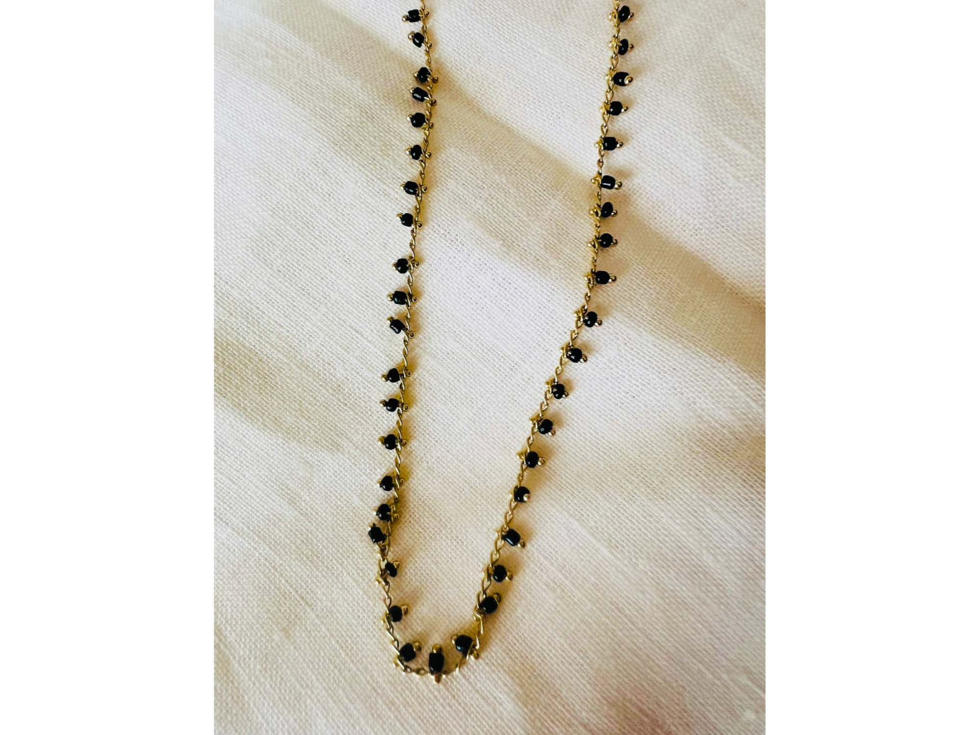 Collar dorado con dijes negros