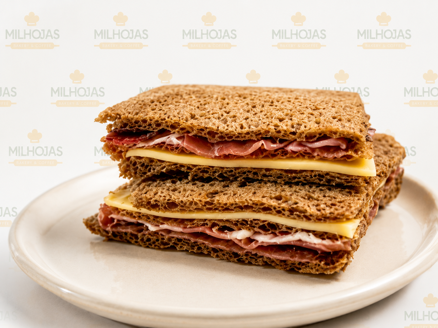 MIGA PAN NEGRO JAMON CRUDO Y QUESO de Mil Hojas Bakery - COLINAS