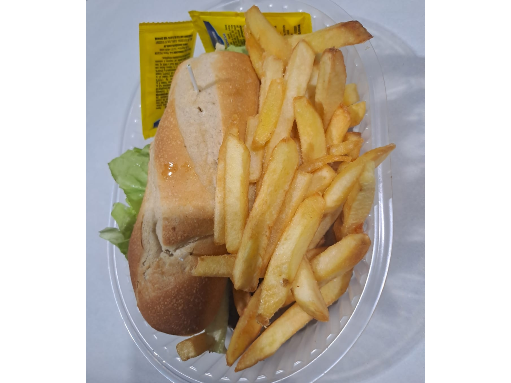 Sandwich de milanesa de carne con lechuga y tomate con fritas