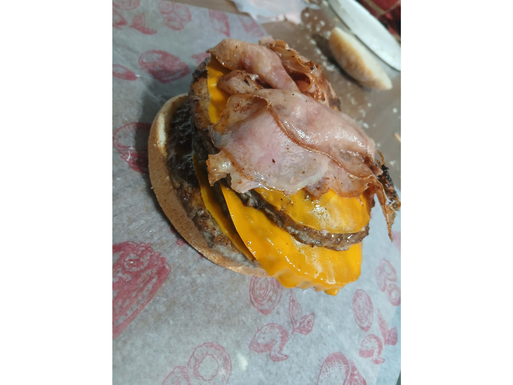 Hamburguesa doble cheddar, bacon y salsa de tomate.